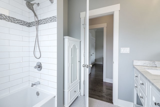 bathroom featuring bathtub / shower combination, vanity, and baseboards
