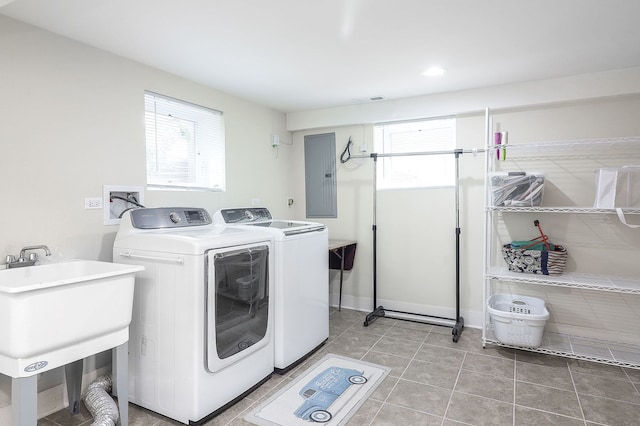 washroom featuring washing machine and dryer, electric panel, plenty of natural light, and light tile patterned flooring