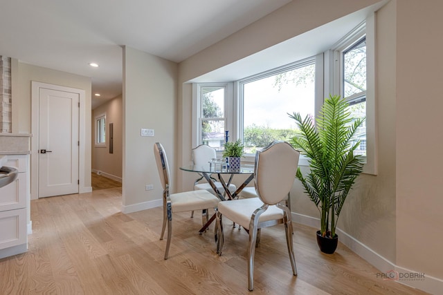 dining space featuring light wood-type flooring, recessed lighting, baseboards, and a wealth of natural light