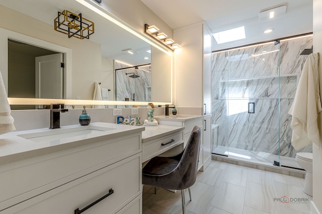 bathroom featuring toilet, a marble finish shower, and vanity