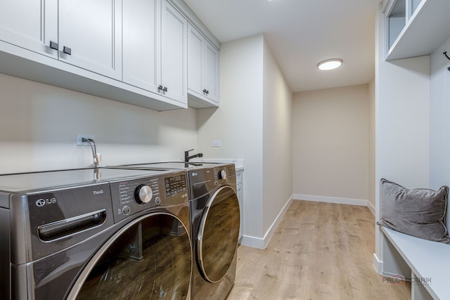 laundry area with separate washer and dryer, baseboards, light wood-type flooring, and cabinet space