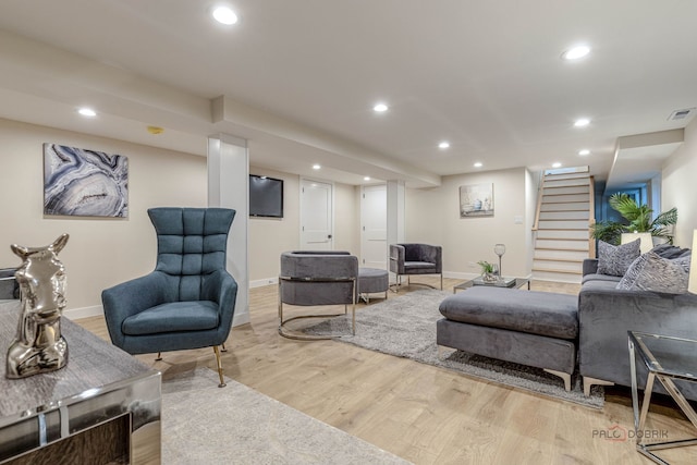 living area with recessed lighting, baseboards, light wood finished floors, and stairs