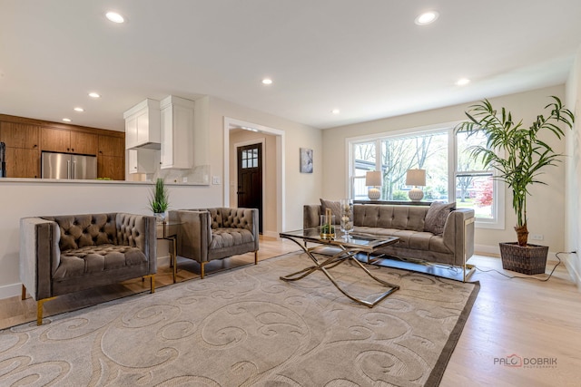 living area with recessed lighting, light wood-style floors, and baseboards