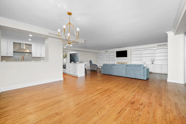 unfurnished living room with ornamental molding, visible vents, and a chandelier