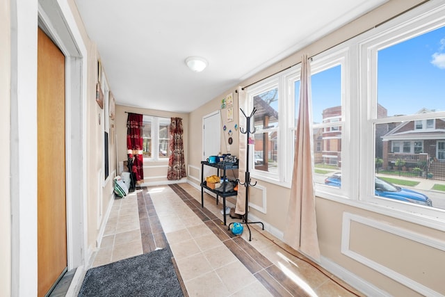 doorway featuring baseboards and light tile patterned floors