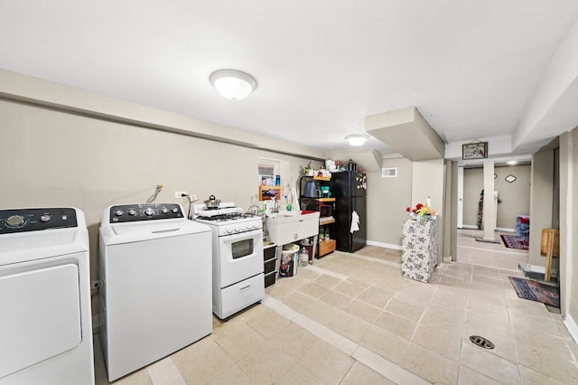 laundry area featuring laundry area, independent washer and dryer, visible vents, light tile patterned floors, and baseboards