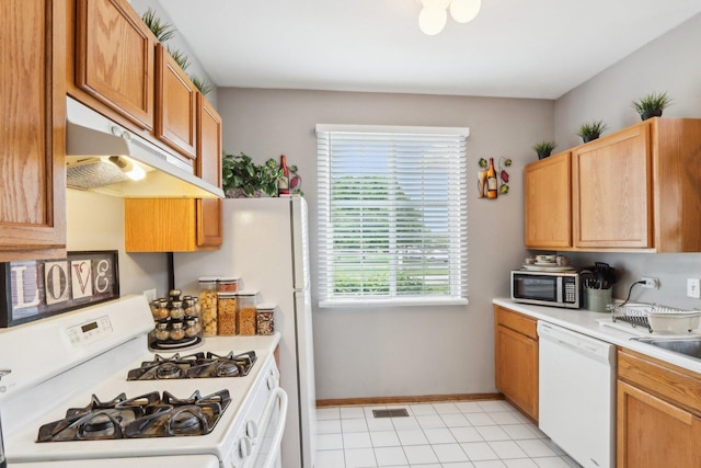 143 Foxglove Unit 143, Romeoville, IL 60446 - kitchen with white appliances, under cabinet range hood, light countertops, light tile patterned flooring, and baseboards