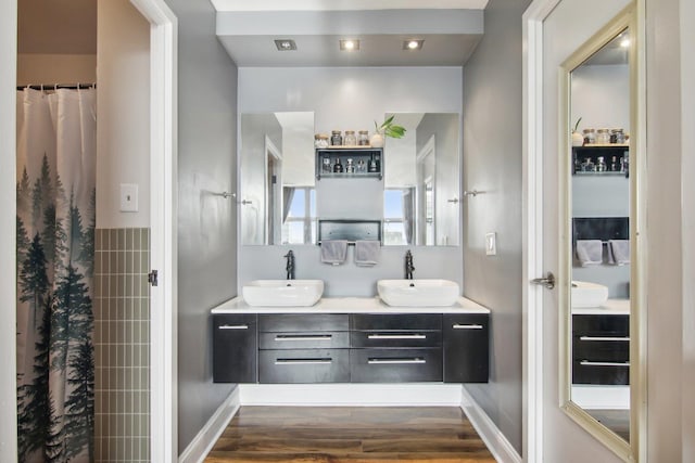 bathroom featuring double vanity, a sink, and wood finished floors