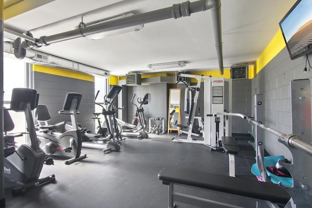 gym featuring visible vents and concrete block wall