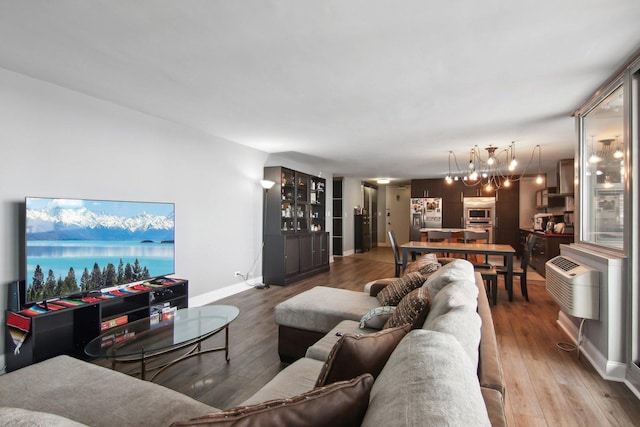 living room featuring baseboards, wood finished floors, and a notable chandelier