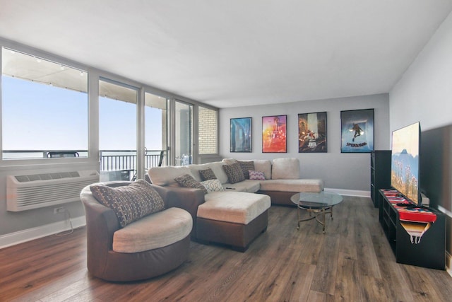 living room featuring baseboards, wood-type flooring, and a wall unit AC