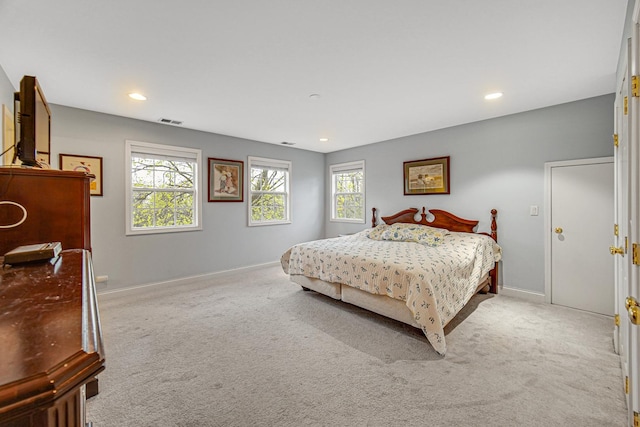 bedroom featuring visible vents, multiple windows, and light carpet