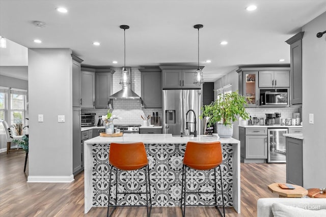 410 Blue Ridge Dr, Oswego, IL 60543 - kitchen featuring beverage cooler, stainless steel appliances, wall chimney exhaust hood, gray cabinets, and backsplash