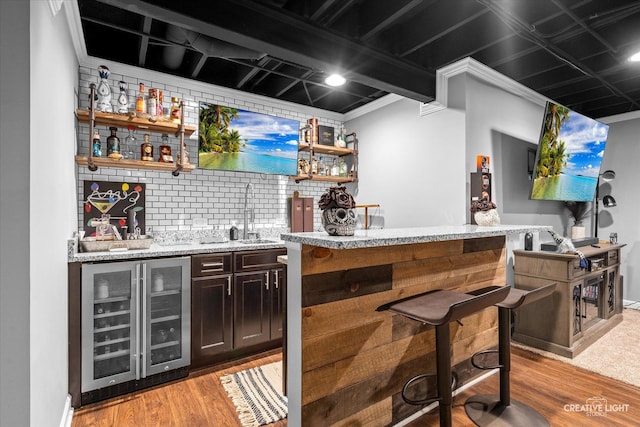 410 Blue Ridge Dr, Oswego, IL 60543 - indoor wet bar with beverage cooler, light wood-style flooring, backsplash, and ornamental molding