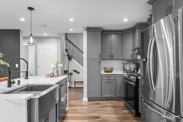 410 Blue Ridge Dr, Oswego, IL 60543 - kitchen featuring appliances with stainless steel finishes, a sink, gray cabinetry, decorative backsplash, and light stone countertops