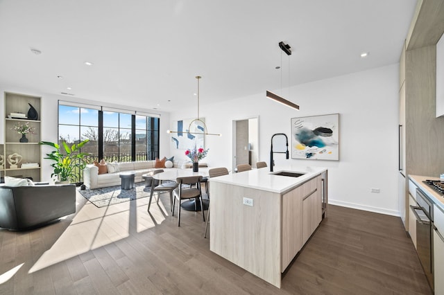 kitchen with a sink, dark wood-style flooring, modern cabinets, and light brown cabinetry