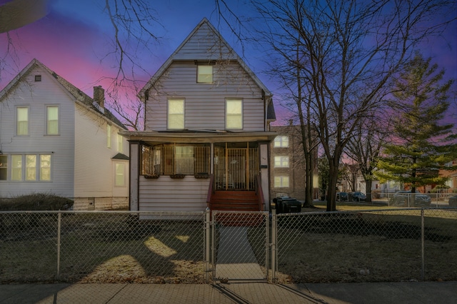 view of front facade with a porch, a fenced front yard, and a gate