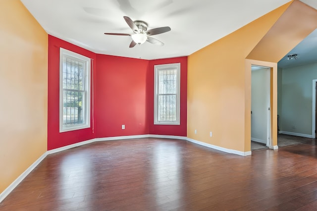 spare room featuring wood-type flooring, a ceiling fan, and baseboards