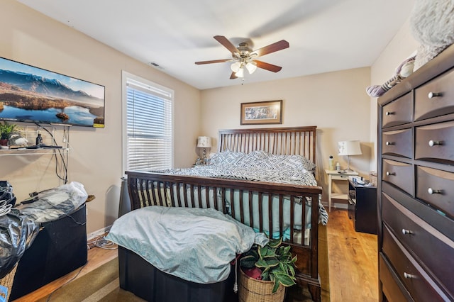 bedroom featuring visible vents, baseboards, ceiling fan, and light wood-type flooring