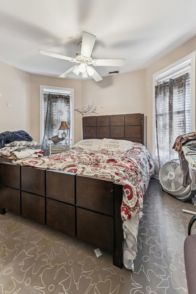 carpeted bedroom featuring ceiling fan and multiple windows