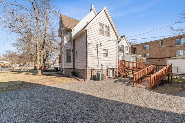 rear view of house featuring central AC, fence, and a wooden deck