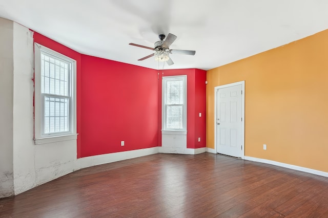 empty room with baseboards, ceiling fan, and wood finished floors