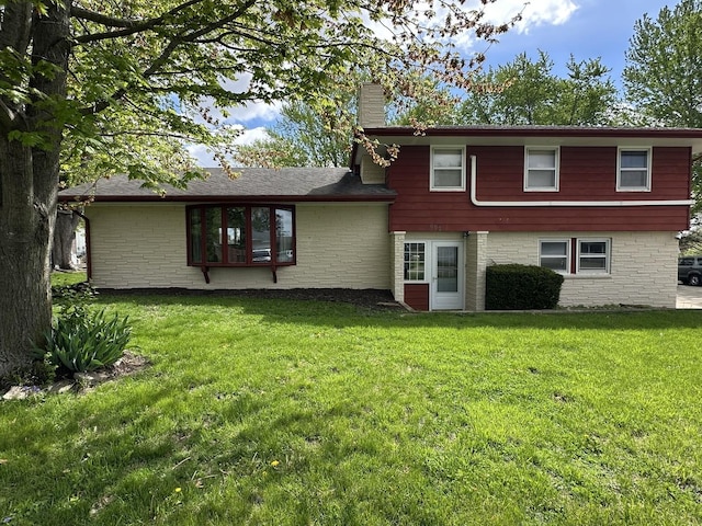 rear view of house featuring a yard and a chimney