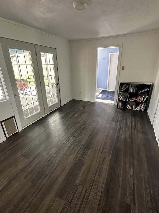 interior space featuring a textured ceiling, baseboards, dark wood-style floors, and ornamental molding