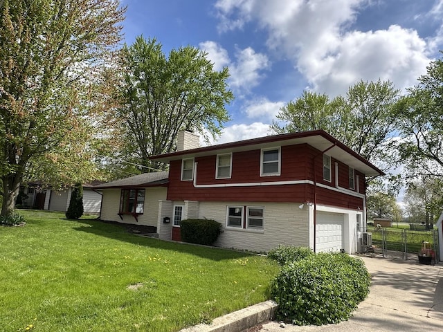 view of side of home featuring a chimney, a lawn, fence, concrete driveway, and an attached garage