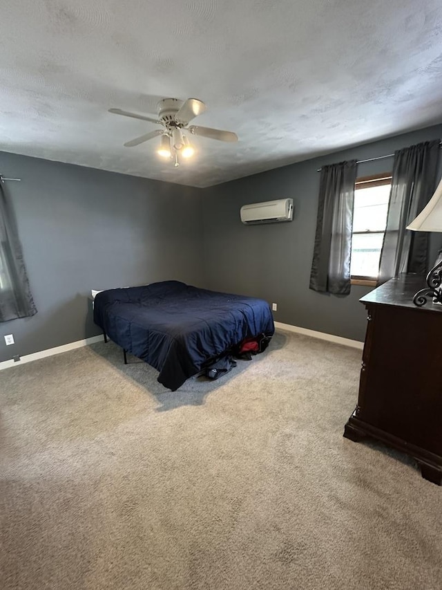 bedroom featuring ceiling fan, an AC wall unit, a textured ceiling, carpet, and baseboards