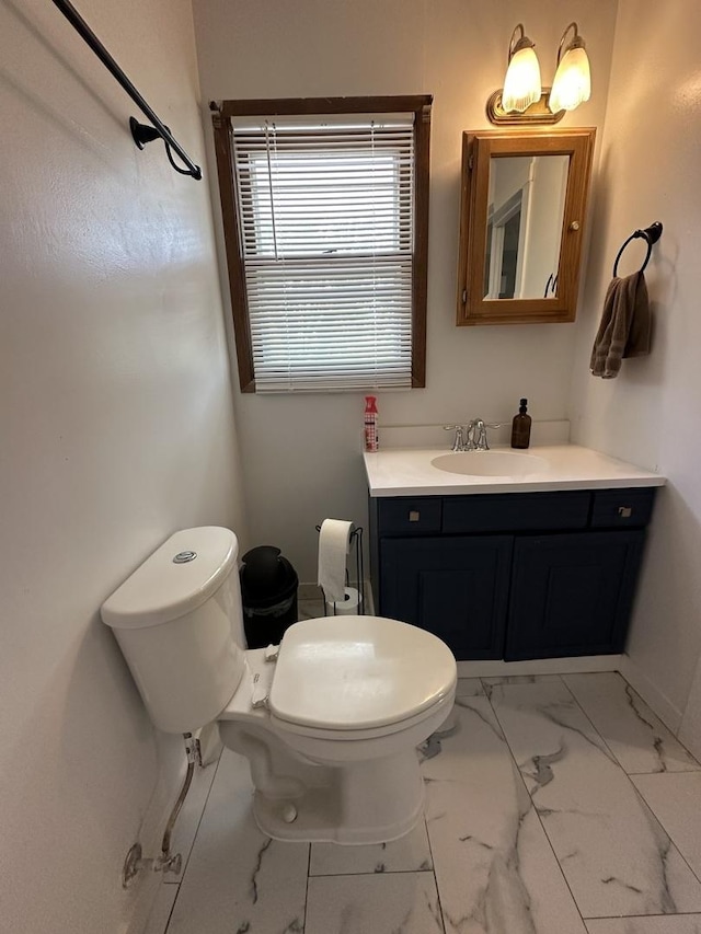 bathroom featuring toilet, marble finish floor, and vanity
