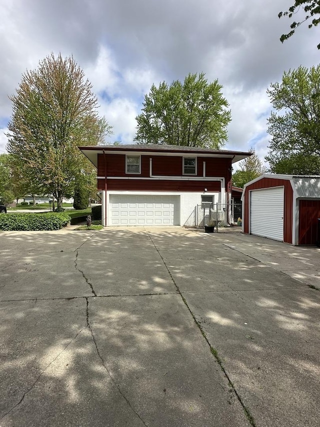 view of front of home with a detached garage and an outbuilding