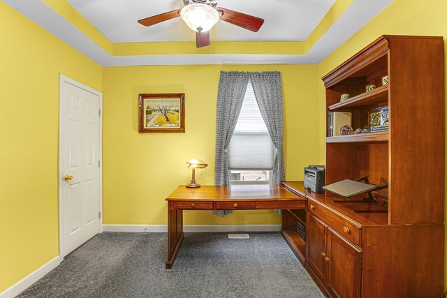 1208 Main St, Crete, IL 60417 - home office featuring a tray ceiling, baseboards, a ceiling fan, and dark carpet