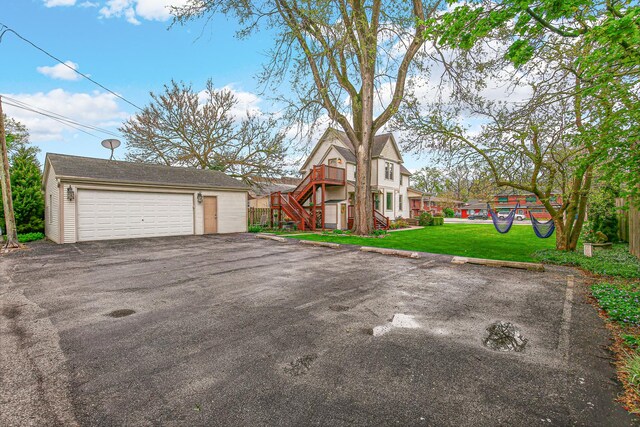 1208 Main St, Crete, IL 60417 - view of front of house featuring an outdoor structure, a front yard, stairway, and a detached garage
