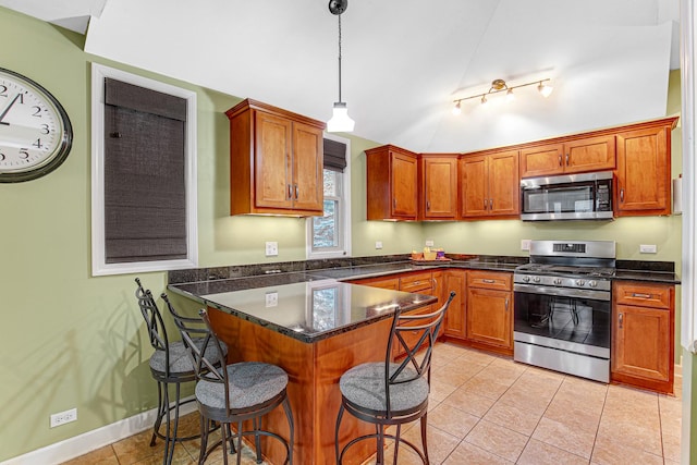 1208 Main St, Crete, IL 60417 - kitchen featuring brown cabinets, a kitchen breakfast bar, stainless steel appliances, a peninsula, and light tile patterned floors