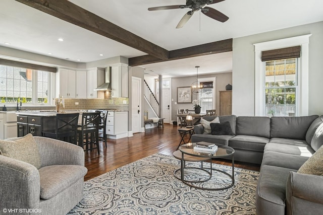 living area with stairs, healthy amount of natural light, dark wood-style flooring, a ceiling fan, and recessed lighting