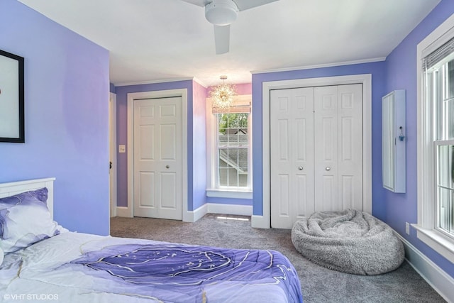 bedroom featuring carpet floors, baseboards, a closet, a chandelier, and crown molding