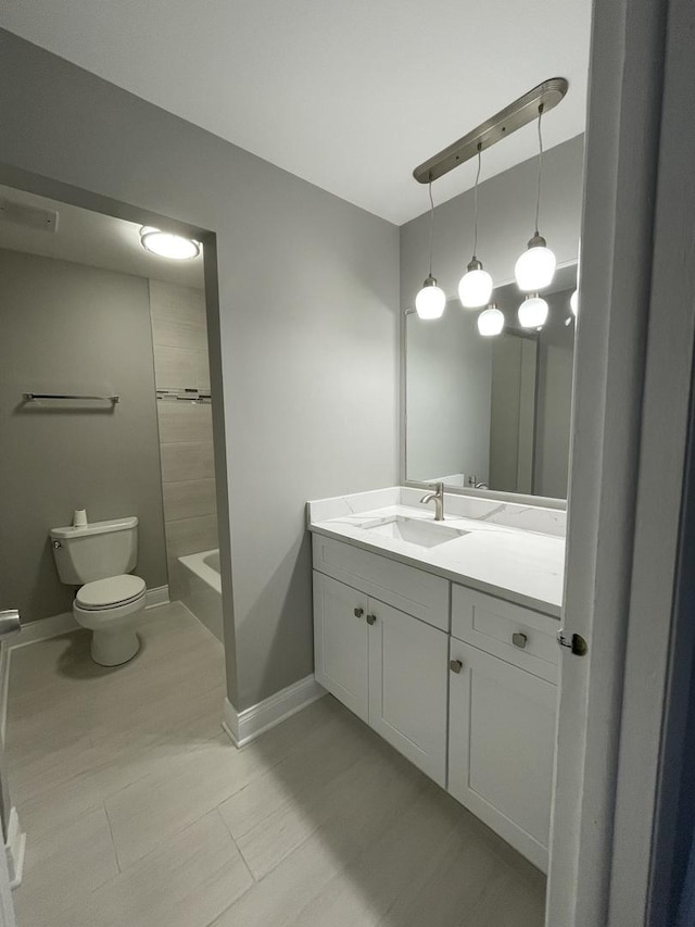 bathroom with vanity, toilet, tile patterned floors, baseboards, and tub / shower combination