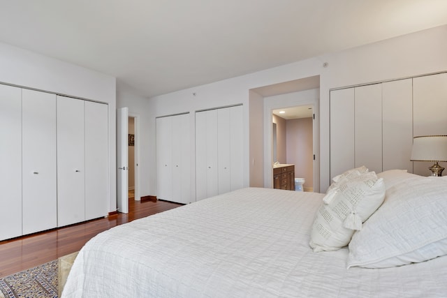 bedroom featuring dark wood-style flooring and two closets