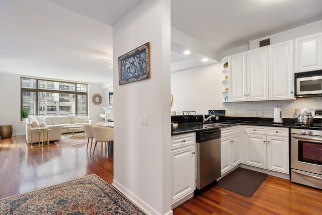 kitchen featuring white cabinetry, dark countertops, appliances with stainless steel finishes, and dark wood-style floors
