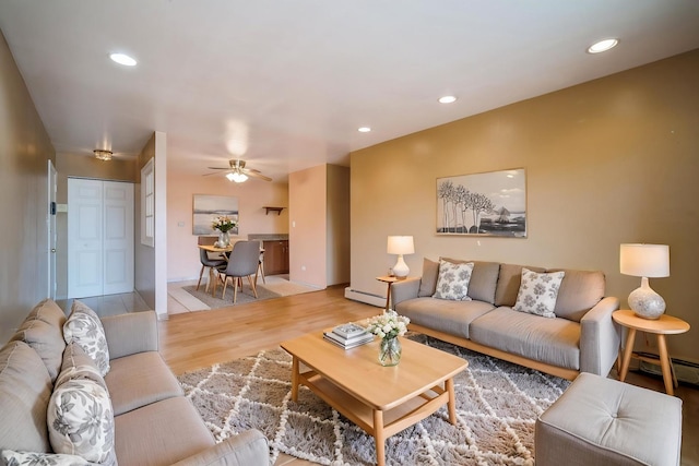living room with light wood-style flooring, a ceiling fan, a baseboard heating unit, recessed lighting, and a baseboard radiator