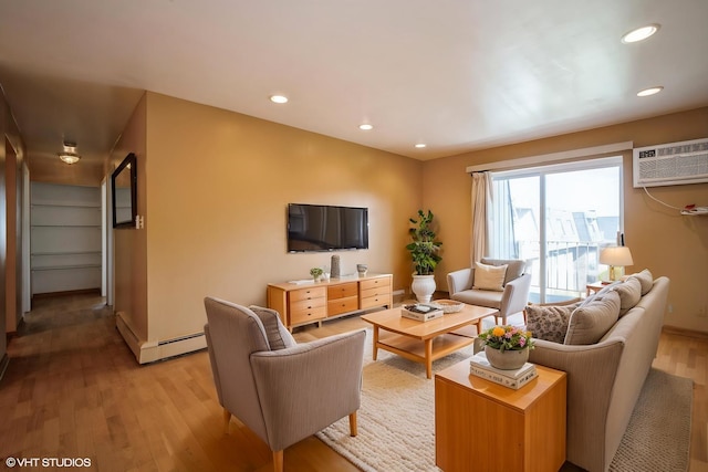 living room featuring a wall unit AC, a baseboard heating unit, light wood finished floors, recessed lighting, and baseboards
