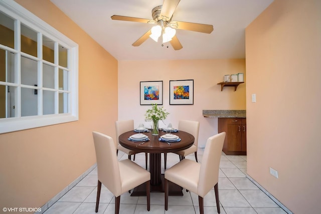 dining area featuring ceiling fan, light tile patterned floors, and baseboards