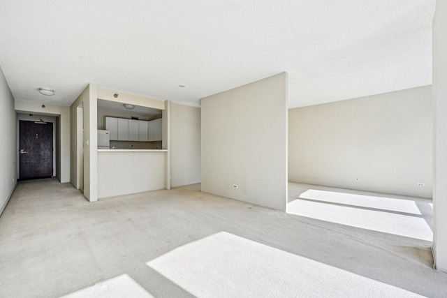 unfurnished living room featuring light colored carpet