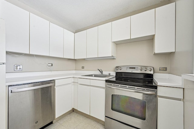 kitchen with light countertops, white cabinetry, a textured ceiling, a sink, and appliances with stainless steel finishes