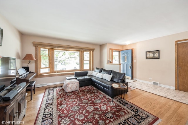 living area featuring light wood-style floors and baseboards