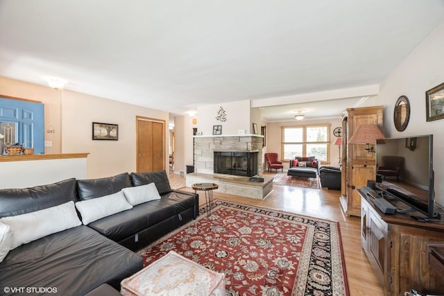 living area featuring light wood-style flooring and a fireplace