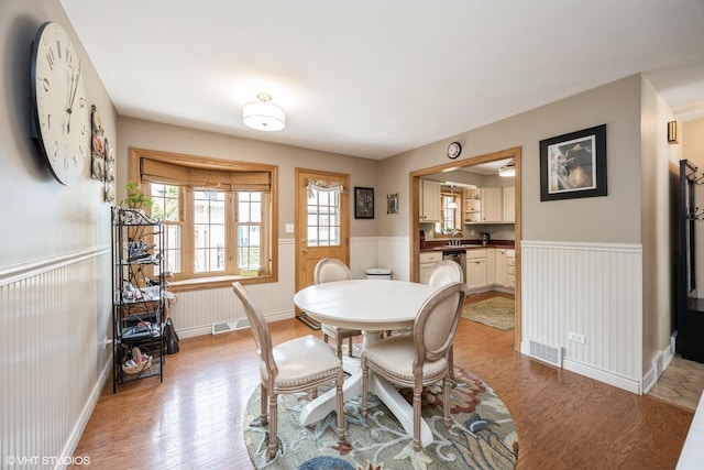 dining room featuring light wood-style floors and wainscoting