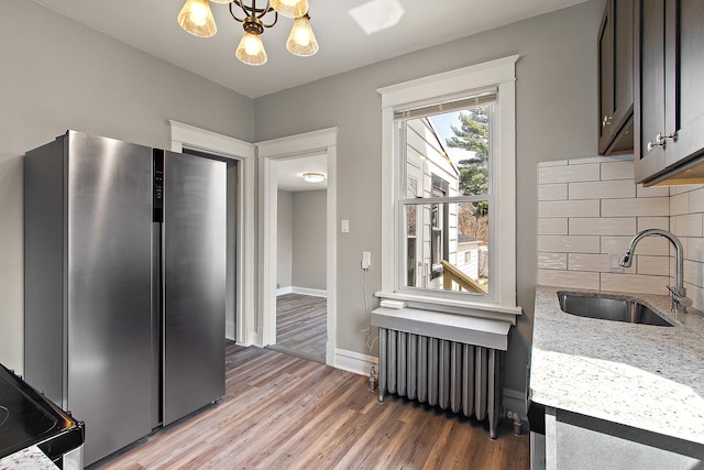 14835 Kildare Ave, Midlothian, IL 60445 - kitchen with a sink, radiator, freestanding refrigerator, light wood-type flooring, and backsplash