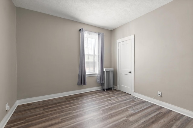 14835 Kildare Ave, Midlothian, IL 60445 - empty room with baseboards, a textured ceiling, radiator, and wood finished floors